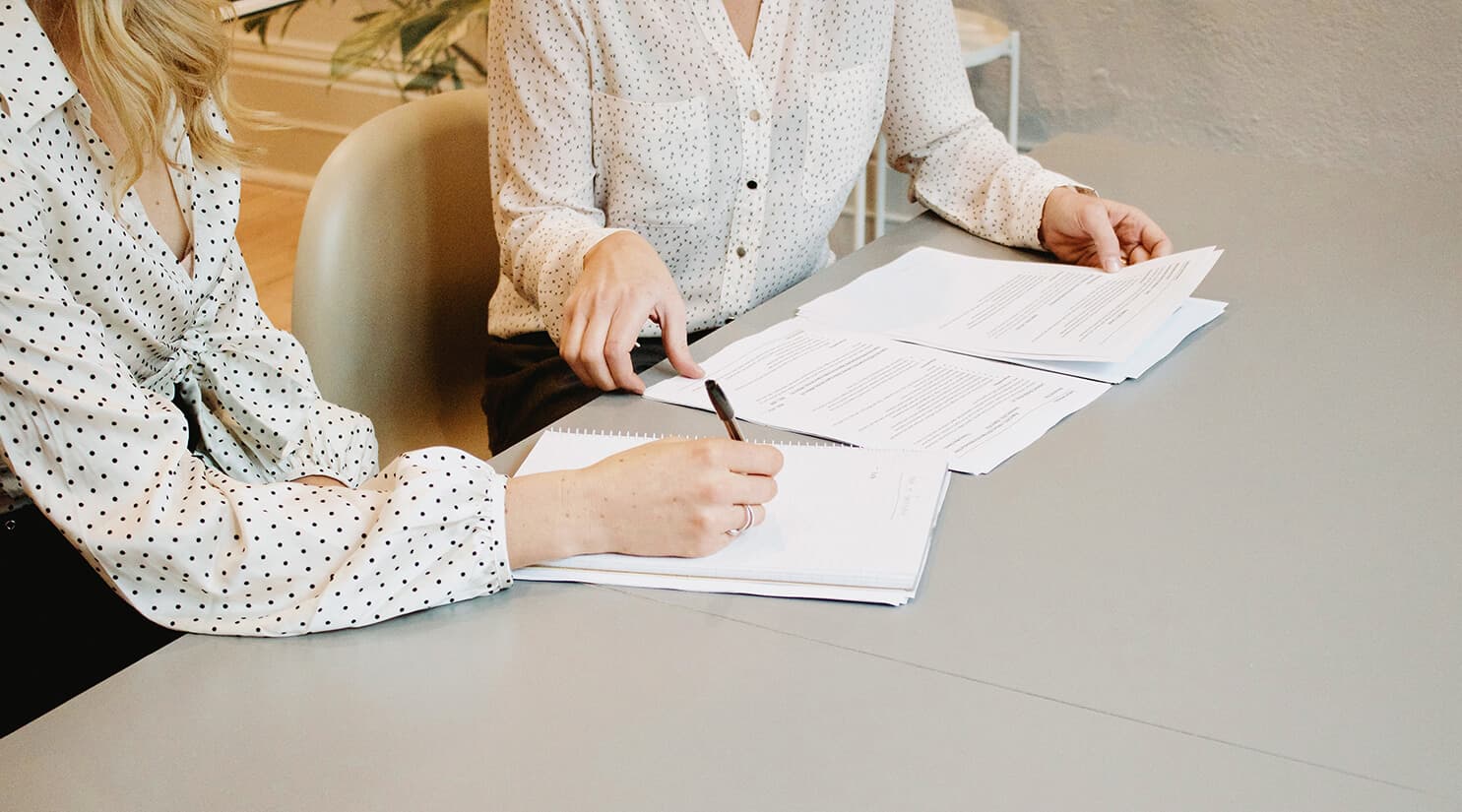 Buyer signing real estate documents at a table