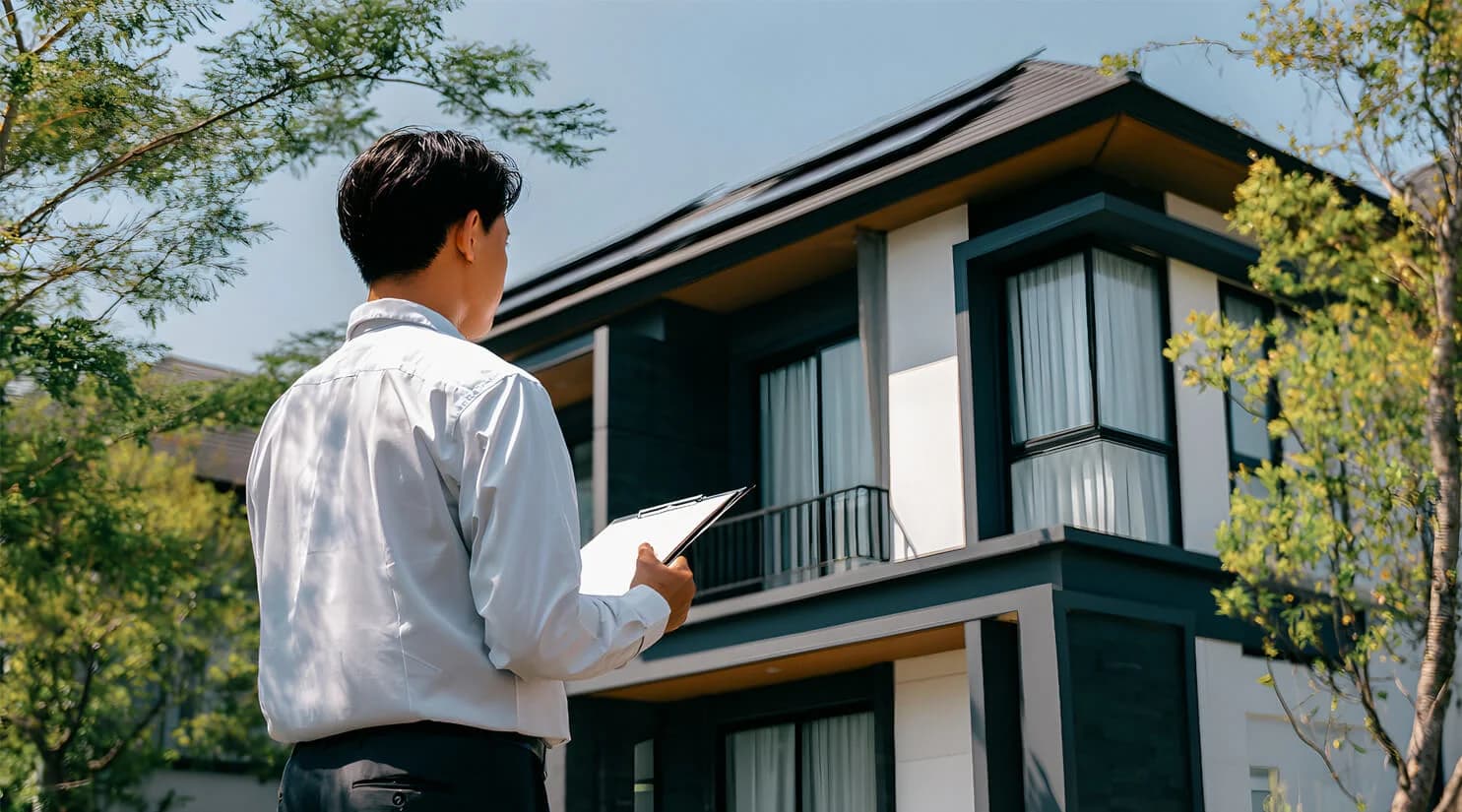 Real estate appraiser reviewing a modern home exterior
